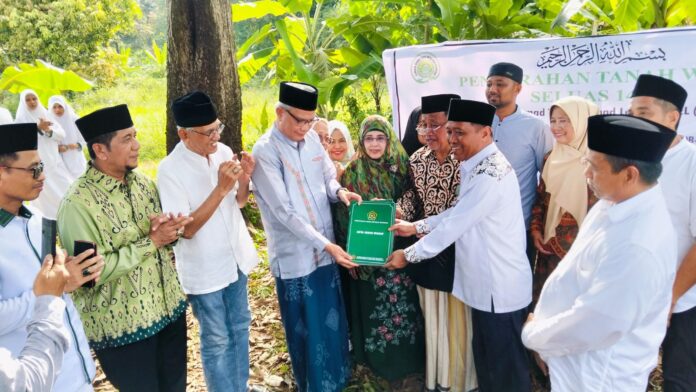 Serah terima dokumen wakaf dari Kepala Kantor Kementerian Agama Kota Makassar kepada Ketua Umum PB DDI Anregurutta Prof. Dr. H. A. Syamsul Bahri A. Galigo, MA, disaksikan oelh wakif dan semua yang hadir di lokasi, Jum'at (09/05/2025).